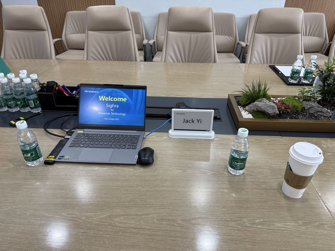 客户接待会议现场，桌面摆放方案演示电脑、姓名牌与国旗